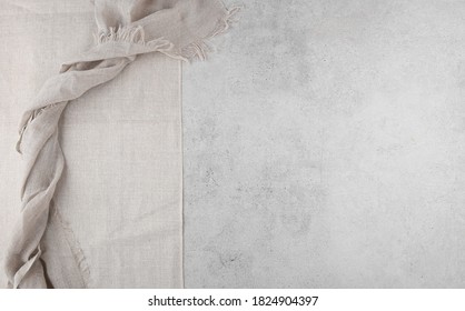 Pure washed linen cloth and tablecloth on light grunge stone background. Natural washed linen fabric on stone tile surface with copy space