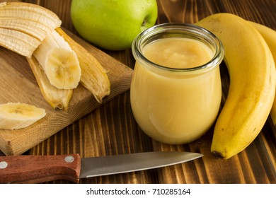 Puree with apples and banana on the wooden background