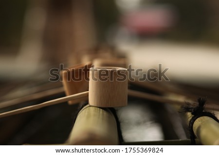 Purifying fountain at a Shinto Shrine in Japan. Image features unfinished wooden cups with long handles that are placed in a decorative way on each side. These cups are used to wash hands before pray.