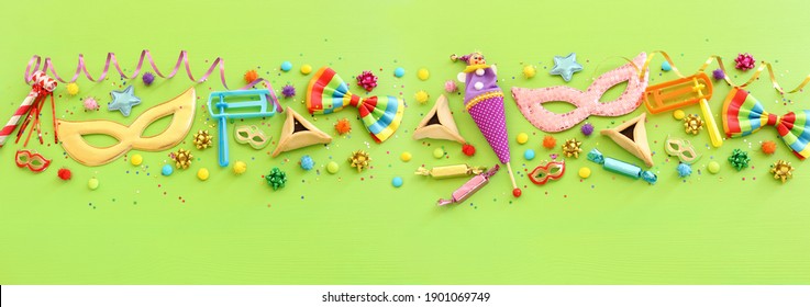 Purim celebration concept (jewish carnival holiday) over wooden green background. Top view, flat lay