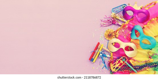 Purim celebration concept (jewish carnival holiday) over pink wooden background