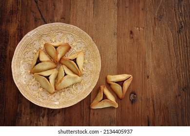Purim celebration concept (jewish carnival holiday). Hamantaschen cookies over wooden background
