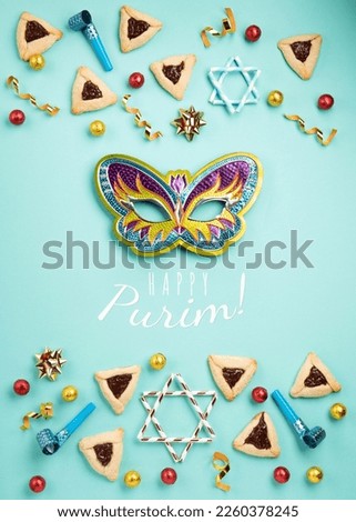 Purim celebration jewish holiday concept. Tasty hamantaschen cookies, Triangular pastry, Carnival mask, noisemaker, sweet candies and festive party decor on mint green background, Top view, copy space