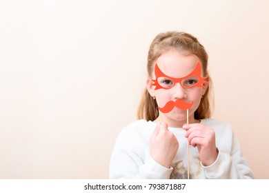 Purim, Fool's Day, Halloween, Birthday Concept.Little Child (girl Age 7-8) With Funny Paper Carnival Mask Cute Lips And Glasses .Copy Space For Text.