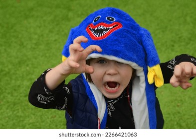 Purim, Halloween. Cute boy in a funny hat with ears. The smile of a child, a festive mood. A boy in a carnival costume. Portrait of a child in a festive headdress.