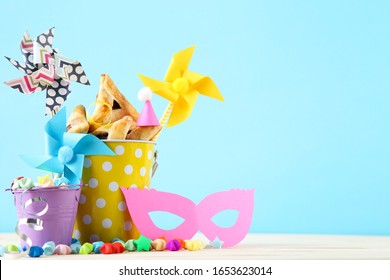 Purim Holiday Composition. Cookies With Buckets And Party Supplies On Blue Background