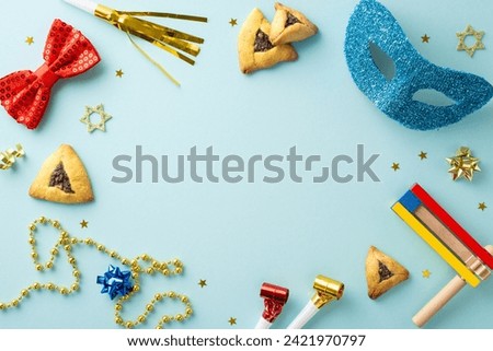 Purim merriment arrangement: Top view snapshot of triangle cookies, Star of David figures, masquerade elements, beads, confetti, party horns on pastel blue foundation, text or advert space available