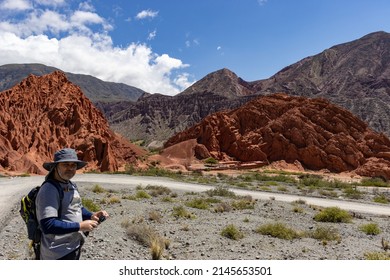 Purmamarca, Jujuy, Argentina. 02-05-2022: Adult Man (45-50 Years Old) Hiking Through The Mountains Of The Seven Colors. Pre-mountain Range. Desert Environment, Walking And Driving Trails. Off Road.