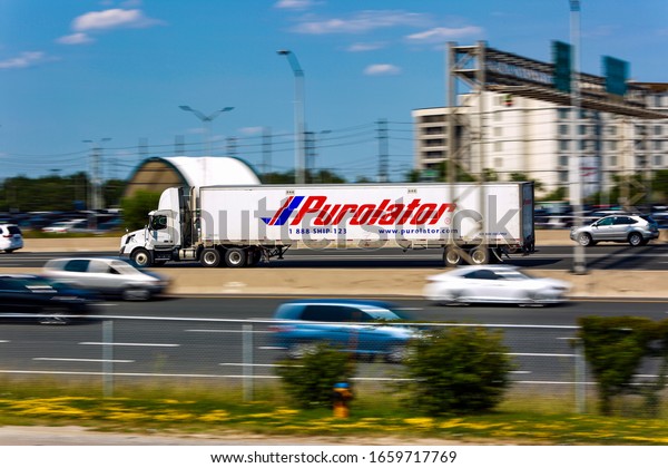Purolator Truck\
Running on Highway with other traffic cars and building  Motion\
Blur  - Toronto, Ontario,\
Canada