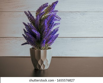 Purple Artificial Lavender Like Plant Sitting In A Black Slate Surface With A Gray Shiplap Background.  Pretty Purple Home Decor.