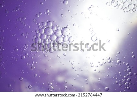 purple  background from small bubbles with sparkling reflections. There are many different sized round shaped bubbles. Stacked in layers, grouped together. mysterious and scientific