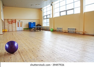 Purple Ball In Empty Gym Laying On Wooden Floor