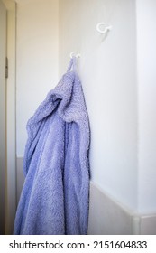 Purple Bath Robe Hanging On A Hook On The Bathroom Wall. Lifestyle. 