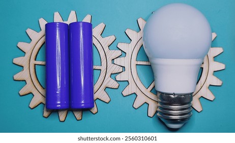 purple battery and white bulb on wooden gear teeth on green background - Powered by Shutterstock