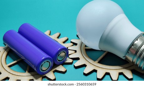 purple battery and white bulb on wooden gear teeth on green background - Powered by Shutterstock