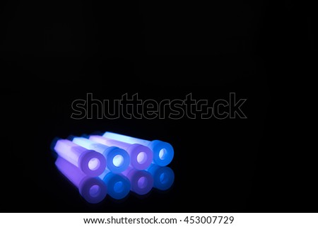 Purple and blue glowsticks on a reflective surface