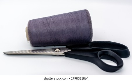 Purple bobbin thread and black scissors isolated on white background. Close up of a spool of purple sewing thread. Thread is a type of yarn but similarly used for sewing.  - Shutterstock ID 1798321864