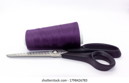 Purple bobbin thread and black scissors isolated on white background. Close up of a spool of purple sewing thread. Thread is a type of yarn but similarly used for sewing.  - Shutterstock ID 1798426783
