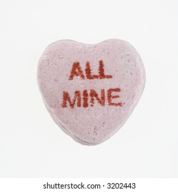 Purple candy heart that reads all mine against white background.
