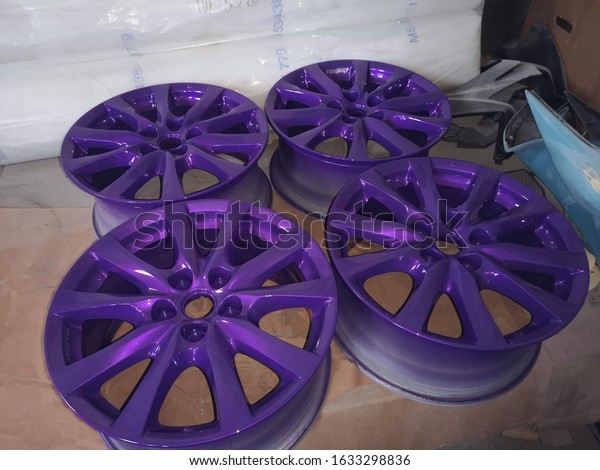 Purple car rims in a professional workshop in the\
paint booth