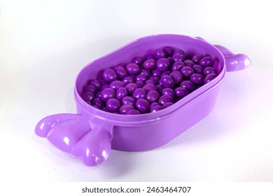 purple chocolate candy balls in a candy-shaped container isolated on white - Powered by Shutterstock