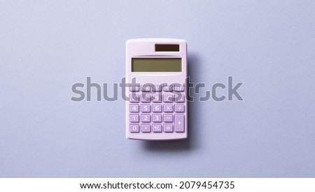 Purple digital calculator isolated on purple background. top view, copy space