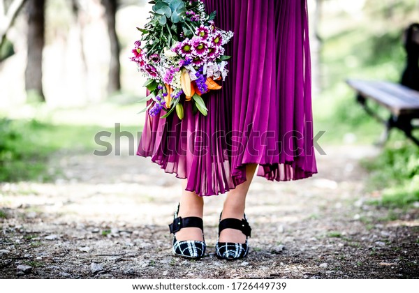 園内に山花のブーケを持つ女性の紫のドレスと足 の写真素材 今すぐ編集