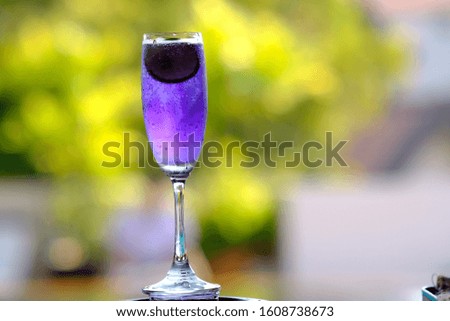 purple drinks and alcoholic cocktails on green background. summer drinks 
