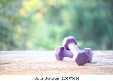 Purple Dumbells On Wooden Table 