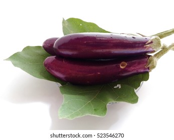 Purple Eggplants On Their Leaf With White Background. An Organic Plant Had Worm Hole.