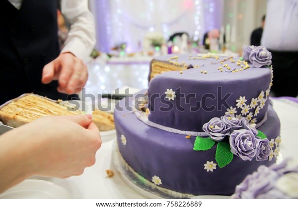 purple festive cake cut into slices. green\
petals lilac roses . celebration\
