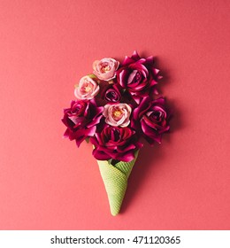 Purple flowers and green icecream cone on pink background. Flat lay.