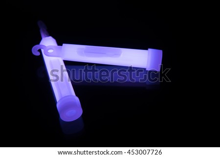 Purple glowsticks on a reflective surface