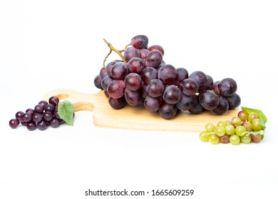Purple grapes on a chopping block  White background