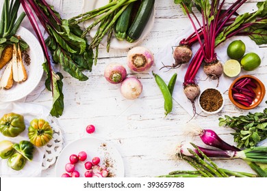 Purple And Green Veggies And Roots Composition On A Rustic White Wooden Table. Beetroot, Red Onion, Radish, Asparagus, Green Tomatoes, Parsnip, Parsley Ready To Prepare Salad. Detox And Diet Food.