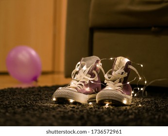 Purple high top shoes with light string and a purple balloon in the background
