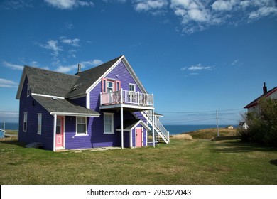 Purple House With Pink Windows Against A Blue Sky In Iles De La Madeleine In Canada