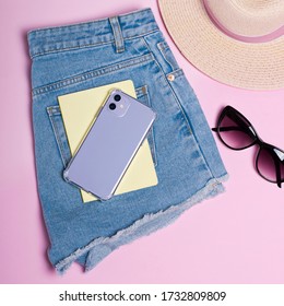 Purple IPhone 11 Case Mockup. Smart Phone Lies On Shorts Close-up, Summer Background, Hat And Sun Glasses Isolated On Pink Background, Top View, Clothing Flat Lay