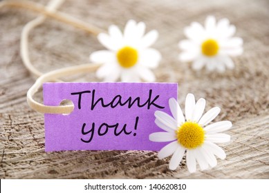 a purple label with Thank you on it and flowers in the background