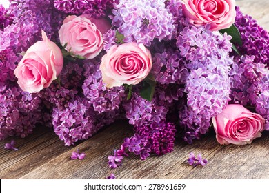 Purple Lilac Flowers With Pink Roses On Wooden Table 