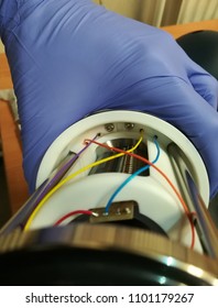 Purple Nitrile Glove Holding A Component Of An Instrument With Coloured Wires 