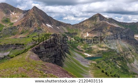 Purple Peaks and Blue Lake - A panoramic view of pristine Blue Lake, nestled beneath colorful peaks, Purple Peak and Afley Peak, of Ruby Range, on a stormy Summer day. Crested Butte, Colorado, USA.