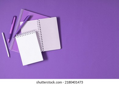 Purple Pencils And Notebooks On Purple Background. Back To School. Office Desk With Copy Space. Flat Lay, Top View