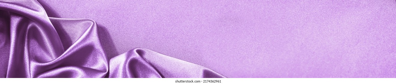 Purple pink silk satin background. Soft folds. Shiny fabric. Luxury lilac background. Space. Design. Web banner. Wide. Website header. Flat lay. Table top view. Birthday, wedding, Christmas, Valentine