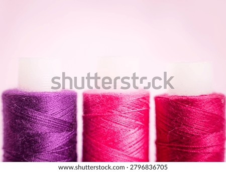 Purple and pink thread spools on white surface, sewing, threads,