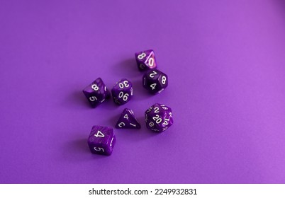 purple polyhedral dice on a dark background. A collection of beautiful polyhedral dice (d4, d6, d8, d10, d12 and d20) for fantasy games.dice and role playing board games - Shutterstock ID 2249932831