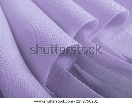 purple polypropylene bag. non-woven fabric with wavy pleats. pile of environmentally friendly bag materials. spunbond bag