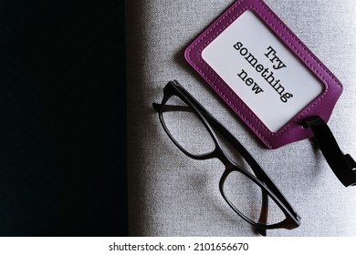 Purple Reading Glasses And ID Card Holder With Black Copy Space Background And Text TRY SOMETHING NEW, To Encourage Midlife Worker To Have Awareness, Inspiration And Action Around New Pathways 