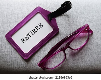 Purple Reding Glasses And ID Card With Text RETIREE, Refer To Person Who Has Retired From Employment Or Stop Working In Regular Paid Full Time Job Because Of Their Age