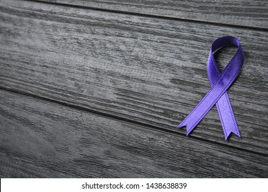 Purple Ribbon On Grey Wooden Background, Space For Text. Domestic Violence Awareness